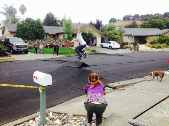 Guy skateboarding on big crack in the street