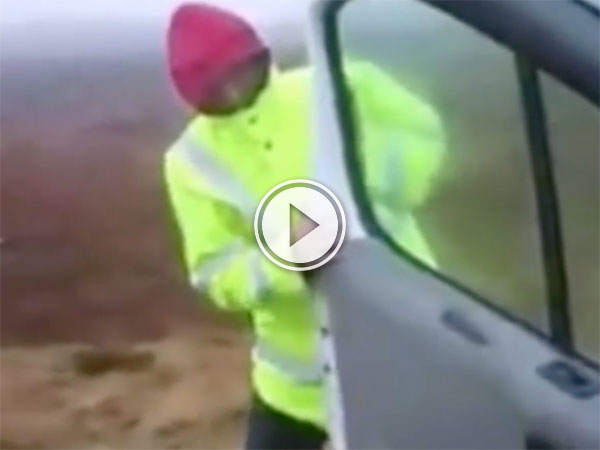 Man struggles with van door in high wind (Video)
