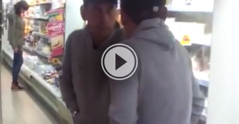 A Russian guy seems like he is trying to get past his reflection in a mirror in the supermarket