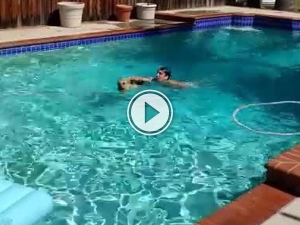 A dog and man swimming in pool.