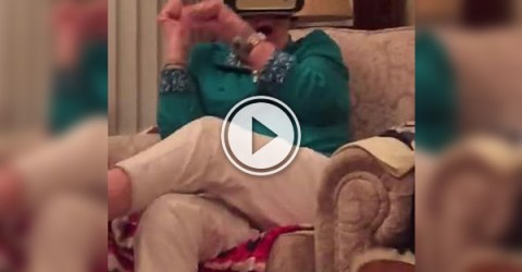 Screenshot of a video with an old woman whose eyes are tied up by a mobile phone