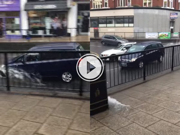 A black SUV running through a water-logged road and splashing water!