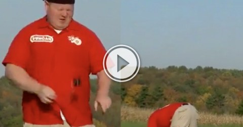 An overweight dude in beige shorts and blue shirt kneeling on green grass with his face down!