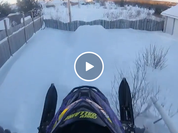 Man jumps his snowmobile through his neighborhood (Video)